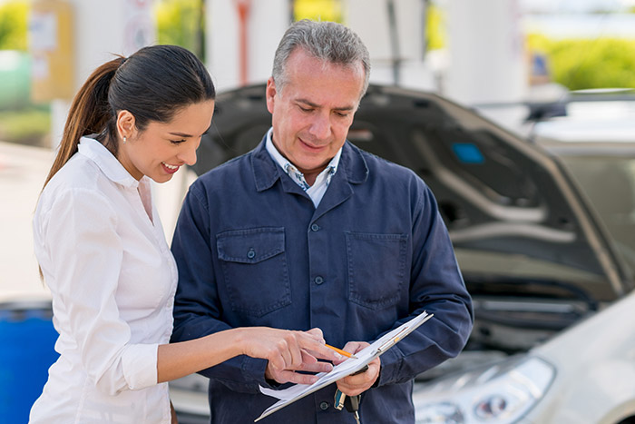 mechanic talking to woman about service repairs