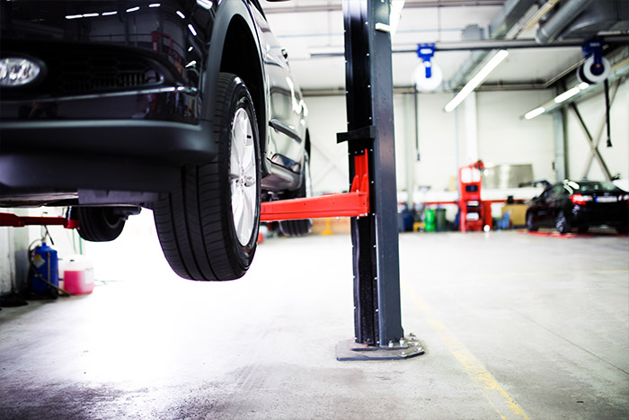 car on lift inside of service garage